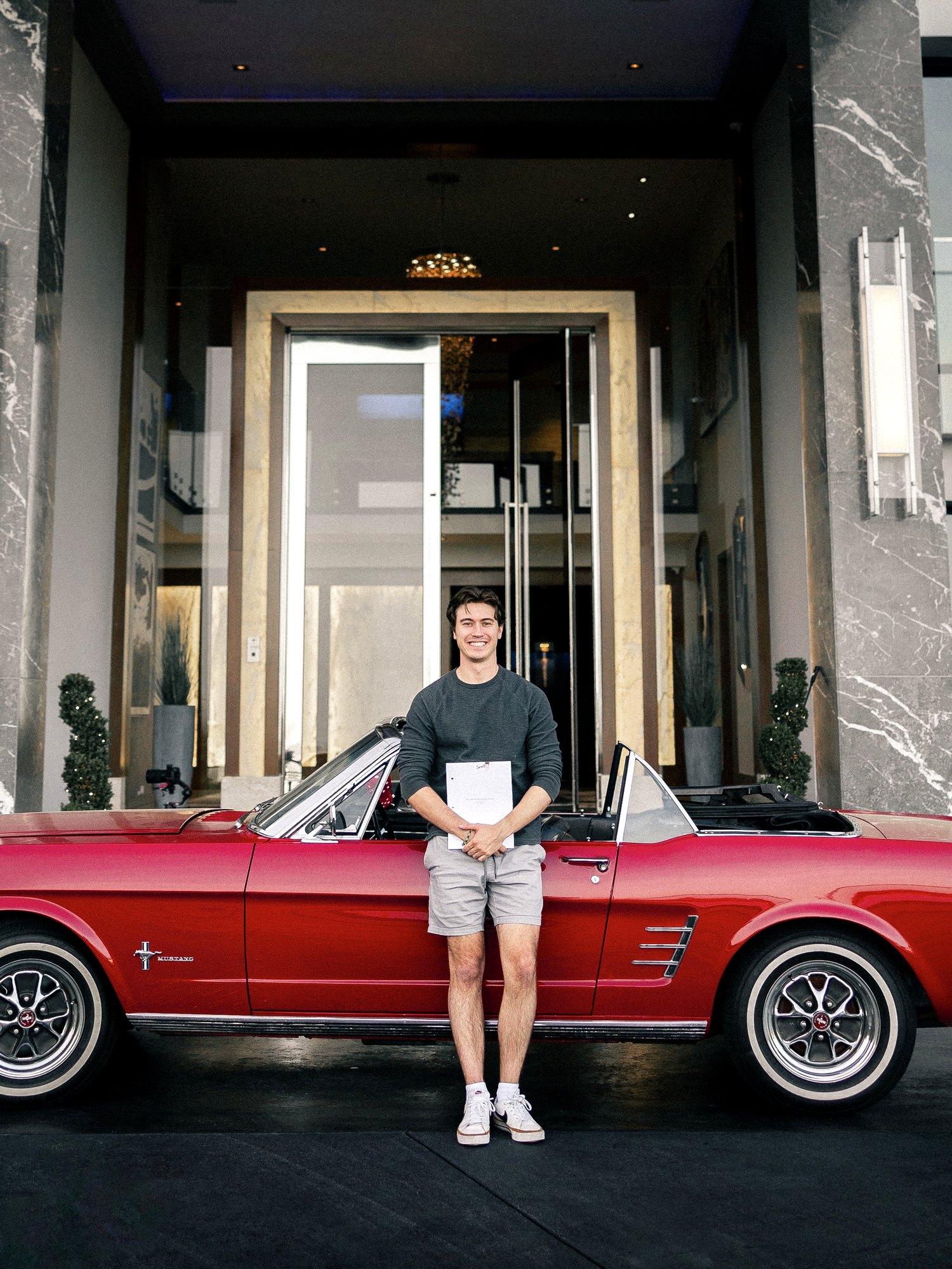 Jacob Geeslin in front of a 1966 Ford Mustang convertible